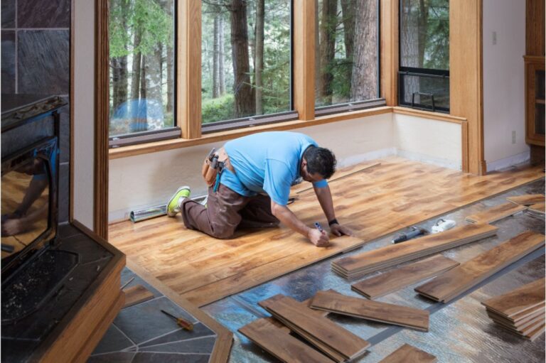 Installer fitting planks during wood floor installation Plano home project