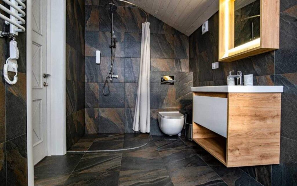 Modern bathroom with dark wall tile reflecting bathroom design Plano TX trends