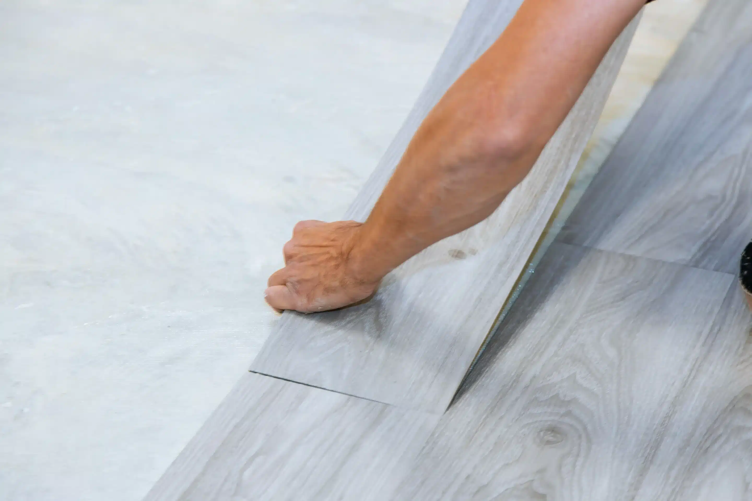 man installing affordable vinyl plank flooring Plano